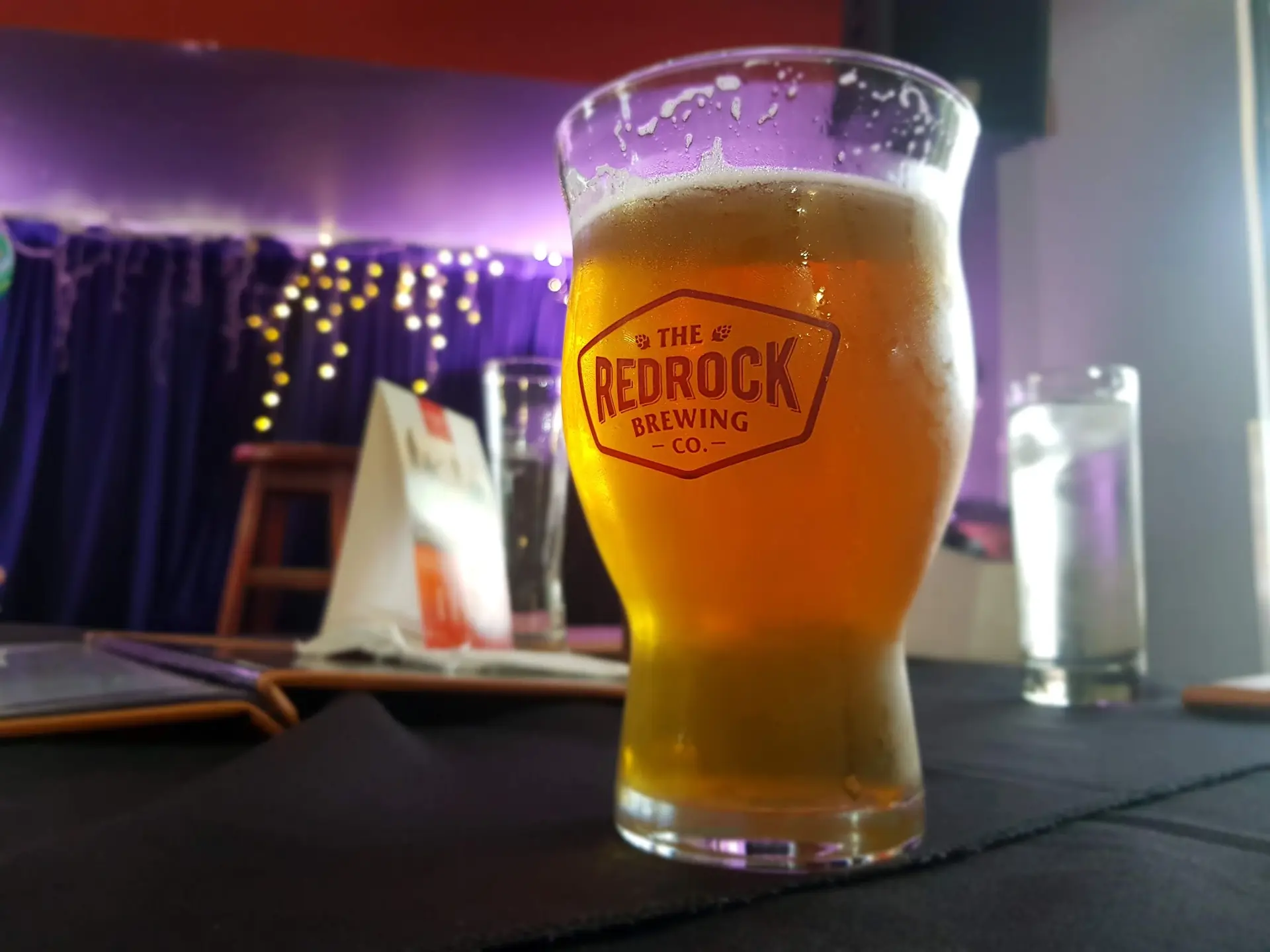 A craft beer on the table in front of the stage